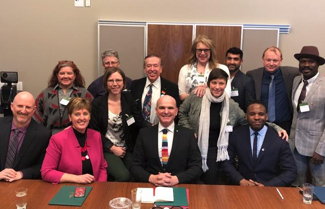 Members of the Dignity Network gathered with Marie-Claude Bibeau, seated, second from left, minister of international development, and Randy Boissonnault, center, special adviser to Prime Minister Justin Trudeau on LGBTQ2 issues, following the announcement of the Canadian government's pledge of $30 million over five years for undeveloped countries. Photo: CNW Group/Rainbow Railroad