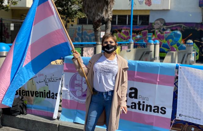 Victoria Castro holds a trans flag as she speaks at a March 19 rally in San Francisco calling for trans people in federal immigration custody to be released. Photo: John Ferrannini