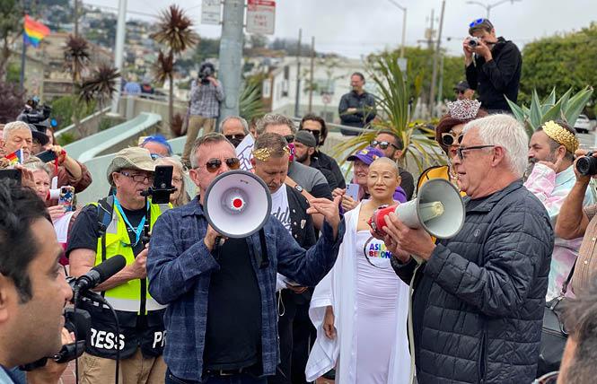Terry Beswick, left, and Cleve Jones spoke during a rally in the Castro Friday saluting longtime ally and union member Allan Baird. Jones is holding the original bullhorn Baird gave to Harvey Milk years ago. Photo: John Ferrannini