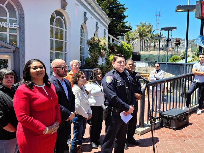 San Francisco Police Officer Mike Petuya, with Chief William Scott to his left, spoke to reporters about Pride safety June 27 in Harvey Milk Plaza as Mayor London Breed, left, and Supervisor Rafael Mandelman listened. Photo: Cynthia Laird