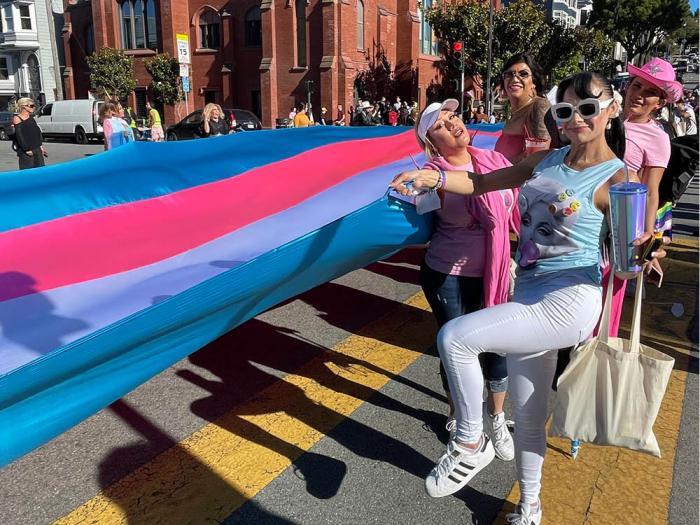 San Francisco Trans March participants stood beside a giant trans flag that was carried during the June 28 event. Photo: JL Odom