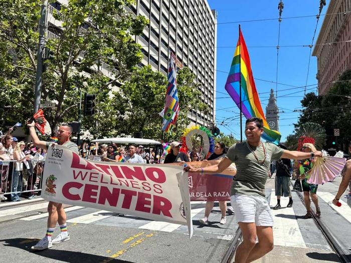 People danced as they carried the Latino Wellness Center banner in the June 30 San Francisco Pride parade. Photo: John Ferrannini
